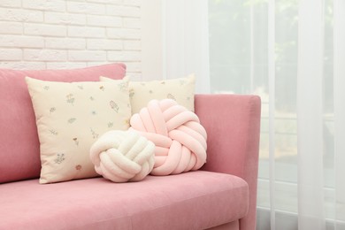 Photo of Soft decorative pillows on pink sofa indoors