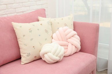 Soft decorative pillows on pink sofa indoors