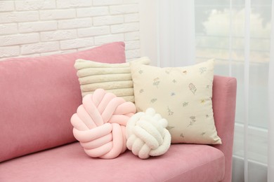 Photo of Soft decorative pillows on pink sofa indoors