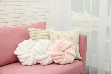 Soft decorative pillows on pink sofa indoors