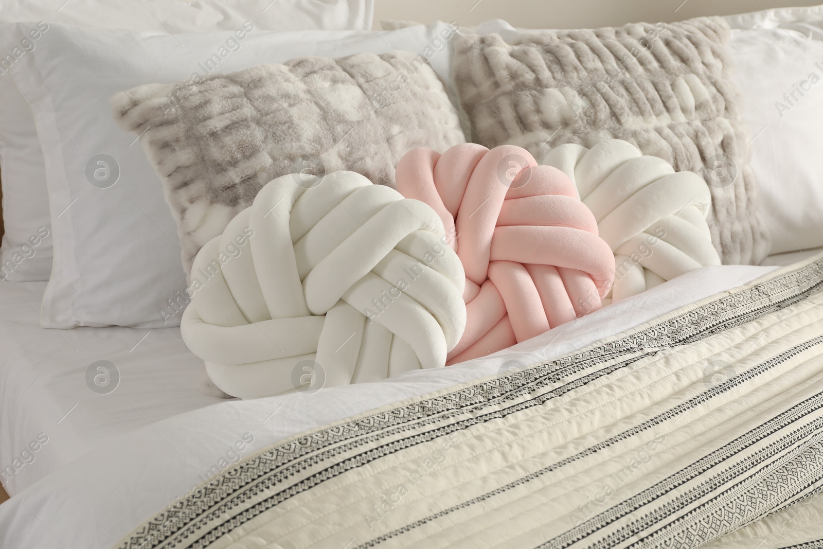 Photo of Different cushions and blanket on bed, closeup