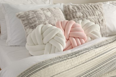 Photo of Different cushions and blanket on bed, closeup