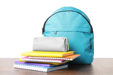 Photo of Backpack with different school stationery on wooden table against white background