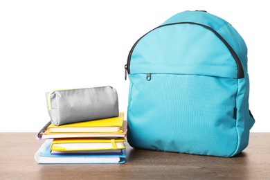 Photo of Backpack with different school stationery on wooden table against white background