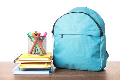 Photo of Backpack with different school stationery on wooden table against white background