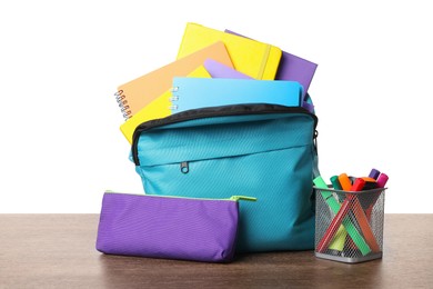 Photo of Backpack with different school stationery on wooden table against white background