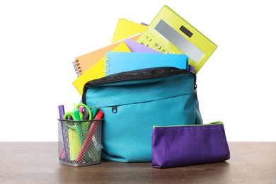 Photo of Backpack with different school stationery on wooden table against white background