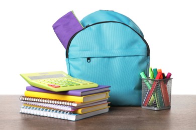 Photo of Backpack with different school stationery on wooden table against white background