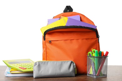 Photo of Backpack with different school stationery on wooden table against white background