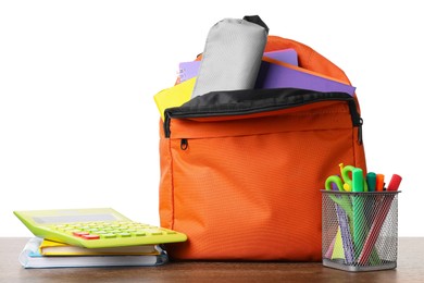 Photo of Backpack with different school stationery on wooden table against white background