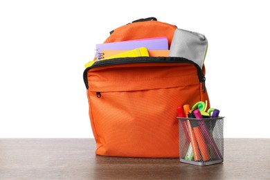 Photo of Backpack with different school stationery on wooden table against white background