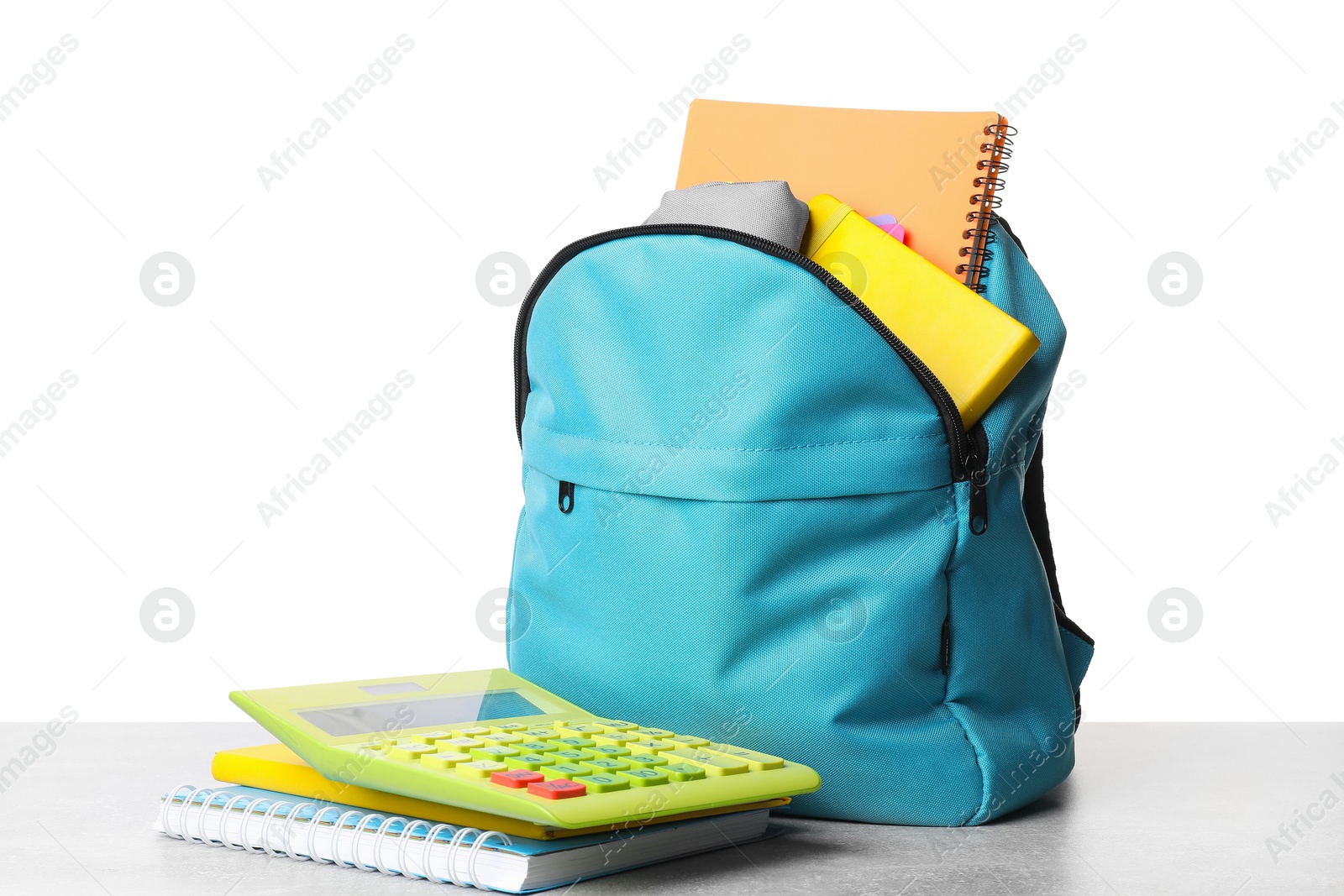 Photo of Backpack with different school stationery on light grey table against white background