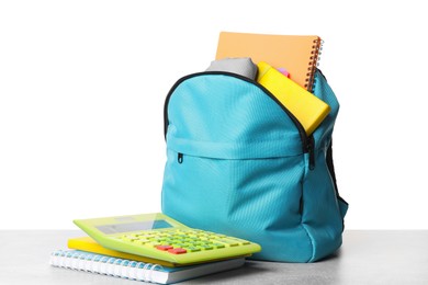 Photo of Backpack with different school stationery on light grey table against white background