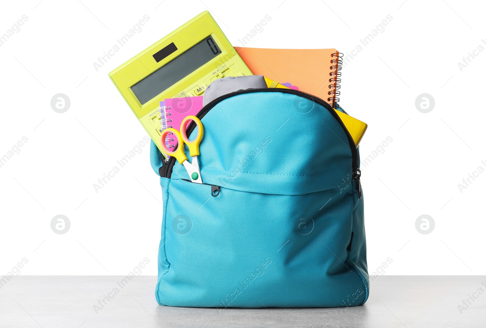 Photo of Backpack with different school stationery on light grey table against white background