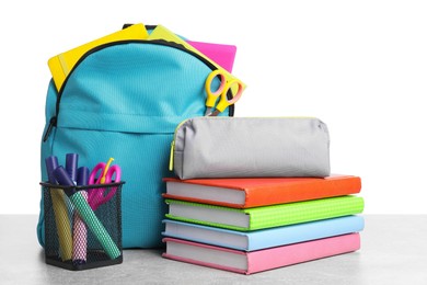 Photo of Backpack with different school stationery on light grey table against white background