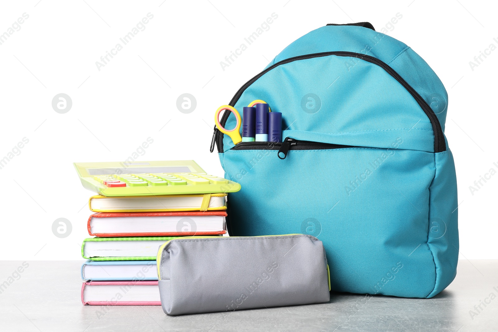 Photo of Backpack with different school stationery on light grey table against white background