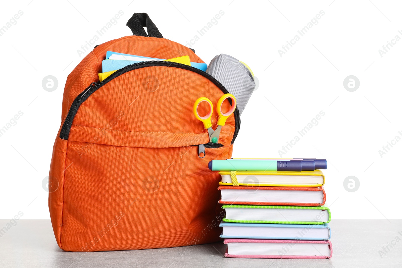 Photo of Backpack with different school stationery on light grey table against white background