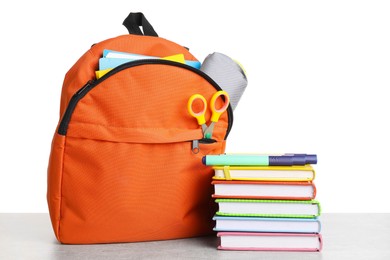 Photo of Backpack with different school stationery on light grey table against white background