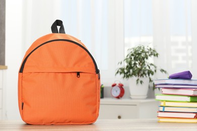 Photo of Backpack with different school stationery on desk in room. Space for text