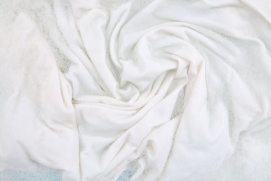 Photo of Washing laundry in water with foam, top view