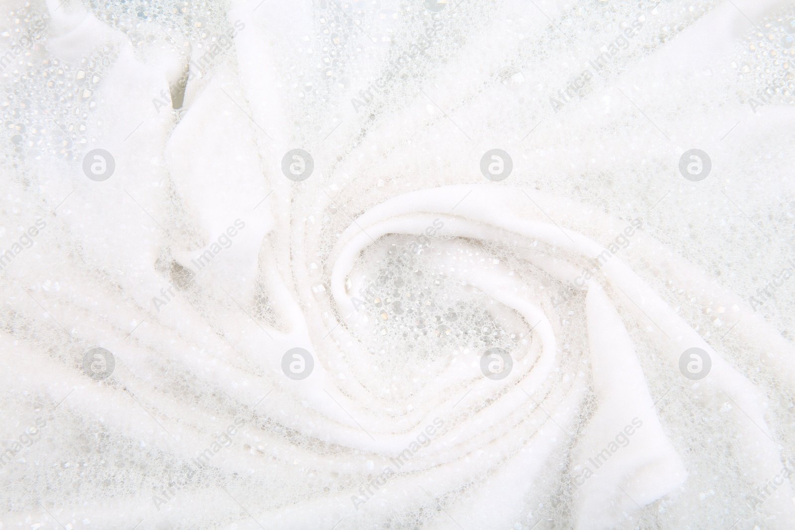 Photo of Washing laundry in water with foam, top view