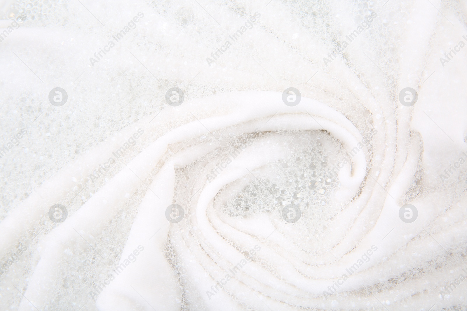 Photo of Washing laundry in water with foam, top view