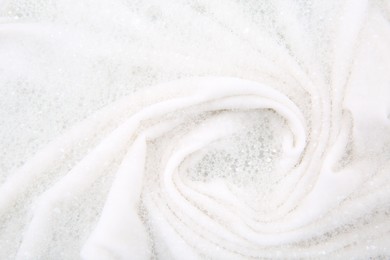 Photo of Washing laundry in water with foam, top view