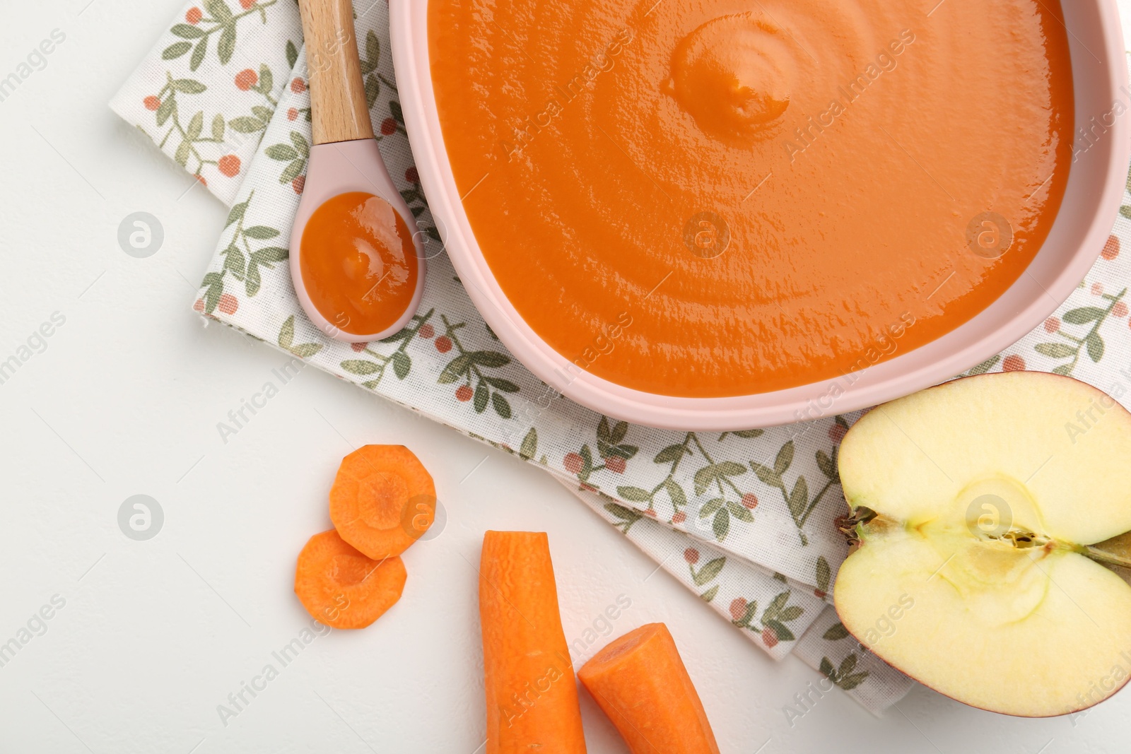 Photo of Delicious baby food in bowl and ingredients on white table, flat lay