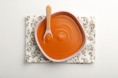 Photo of Delicious baby food in bowl on white table, top view