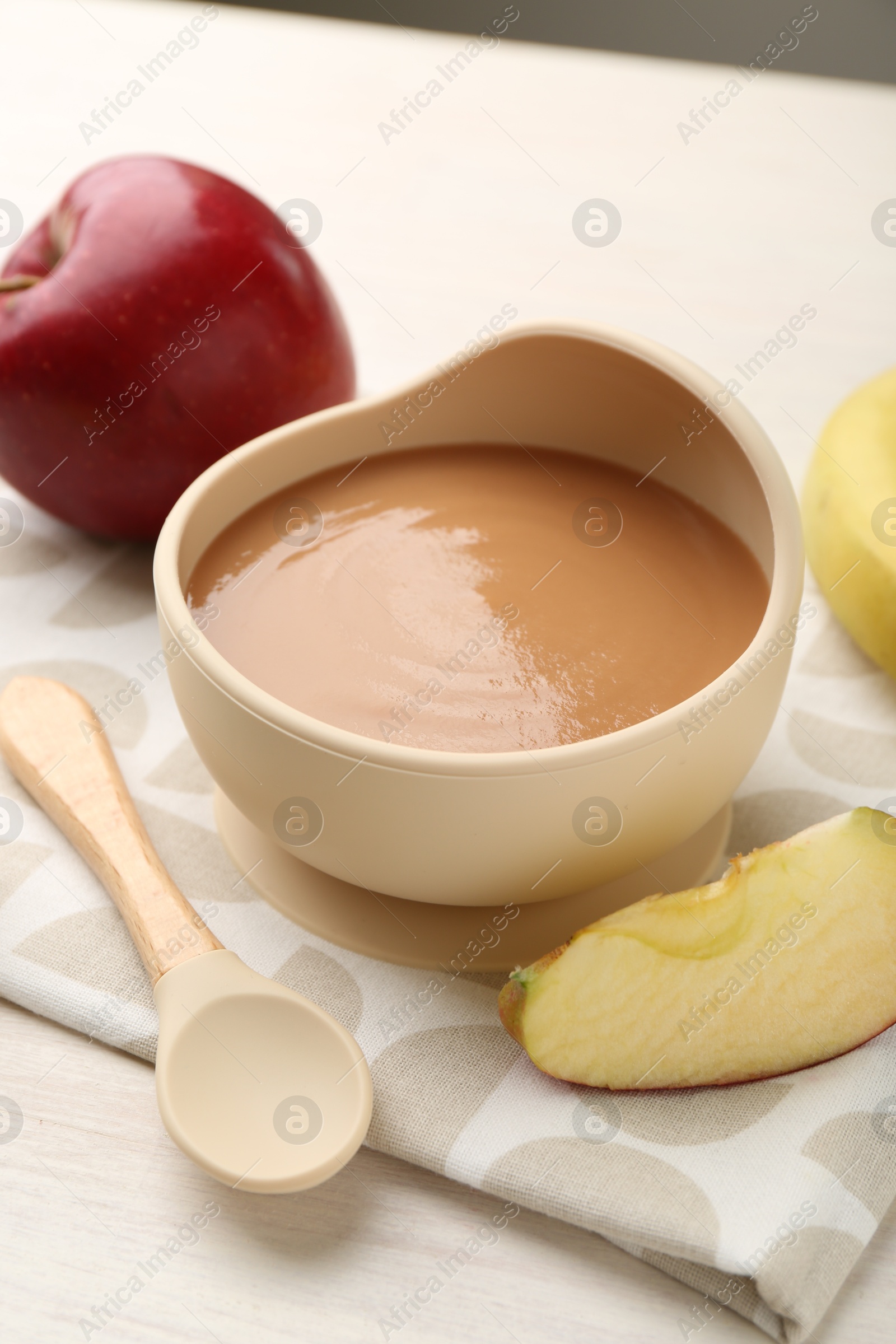 Photo of Delicious baby food in bowl and ingredients on white wooden table