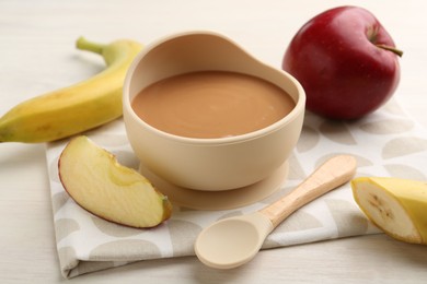 Photo of Delicious baby food in bowl and ingredients on white wooden table