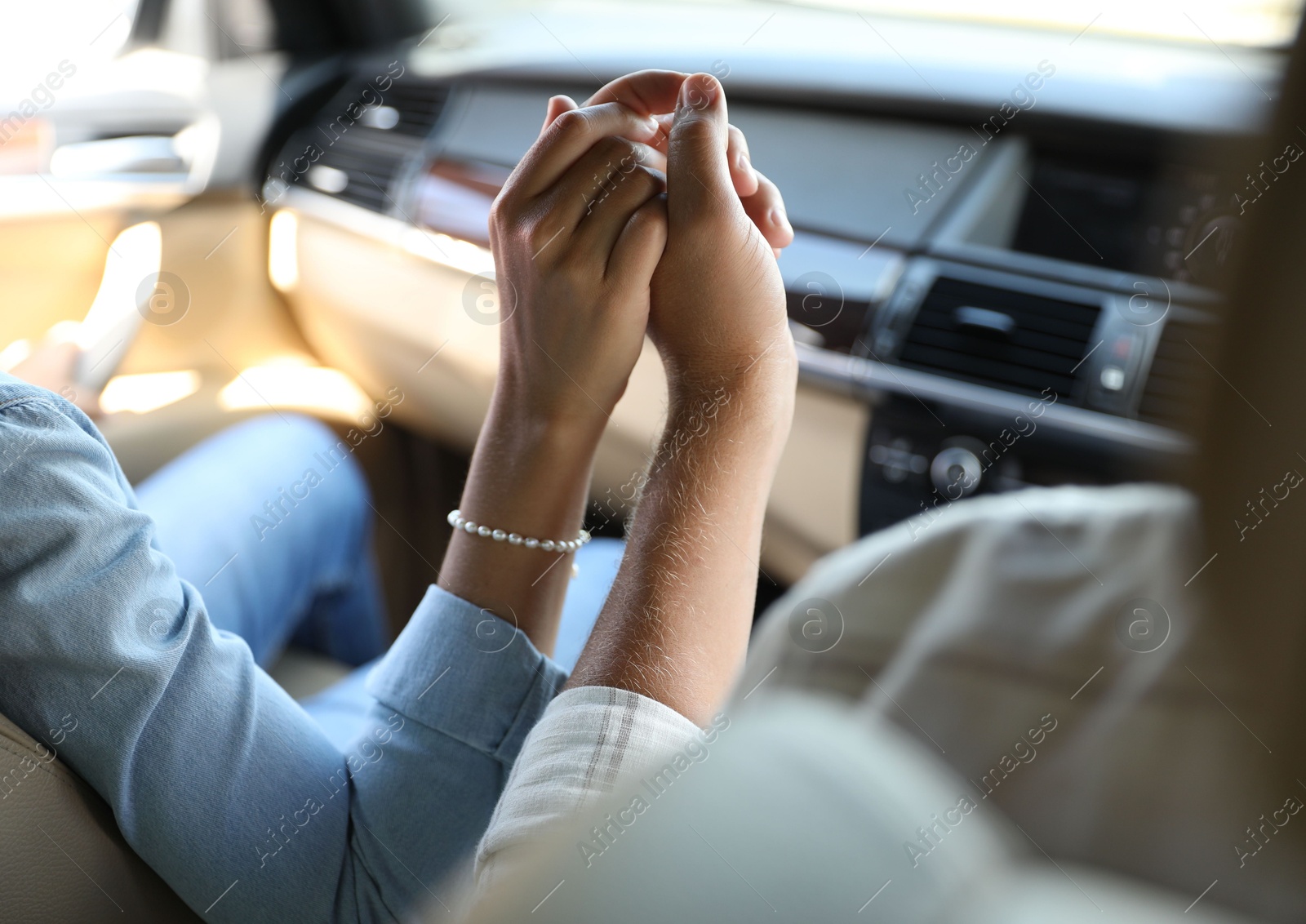 Photo of Lovely couple holding hands together while traveling by car, closeup