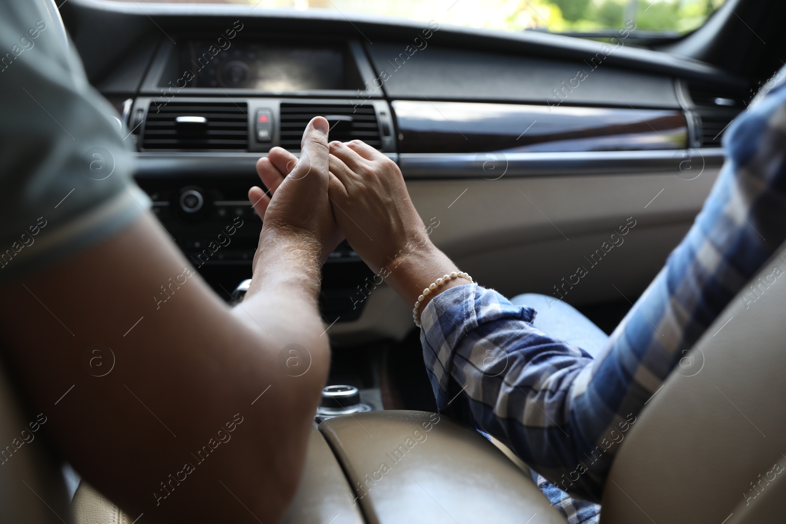 Photo of Lovely couple holding hands together while traveling by car, closeup