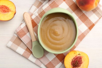 Photo of Delicious baby food in bowl and fresh ingredients on white wooden table, flat lay