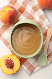 Photo of Delicious baby food in bowl and fresh ingredients on white wooden table, flat lay