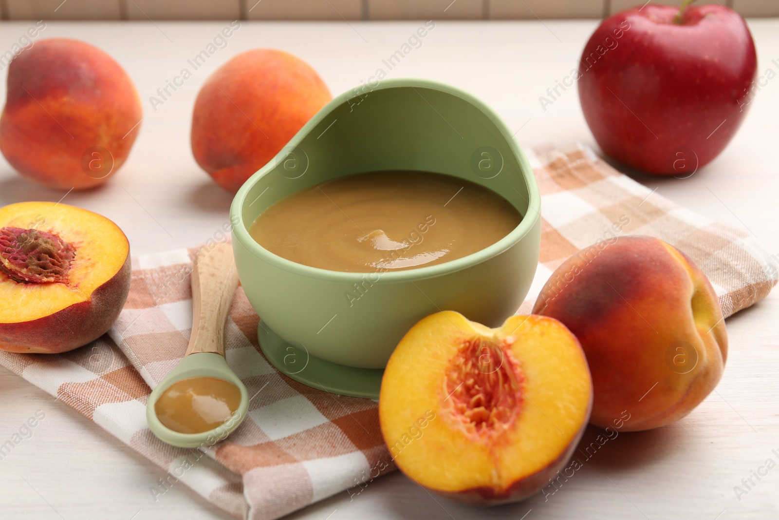 Photo of Delicious baby food in bowl and fresh ingredients on white wooden table