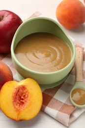 Photo of Delicious baby food in bowl and fresh ingredients on white wooden table