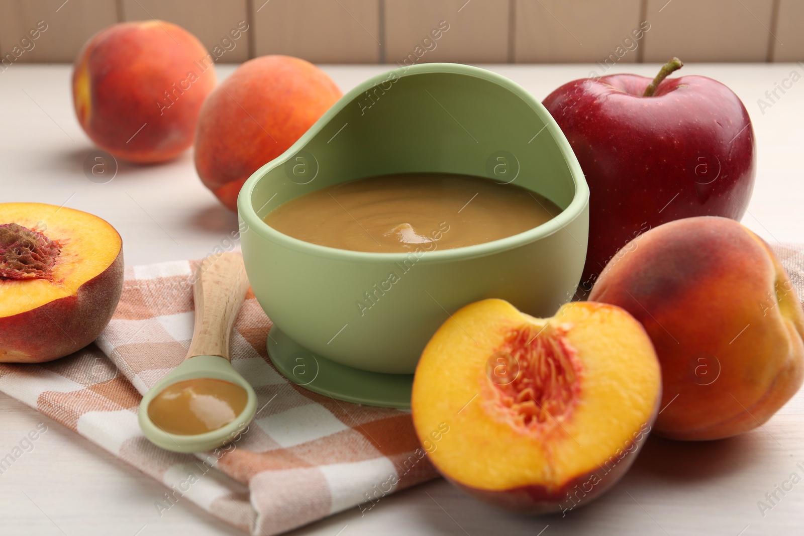 Photo of Delicious baby food in bowl and fresh ingredients on white wooden table