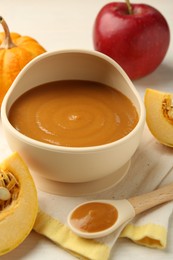 Photo of Delicious baby food in bowl and fresh ingredients on white wooden table