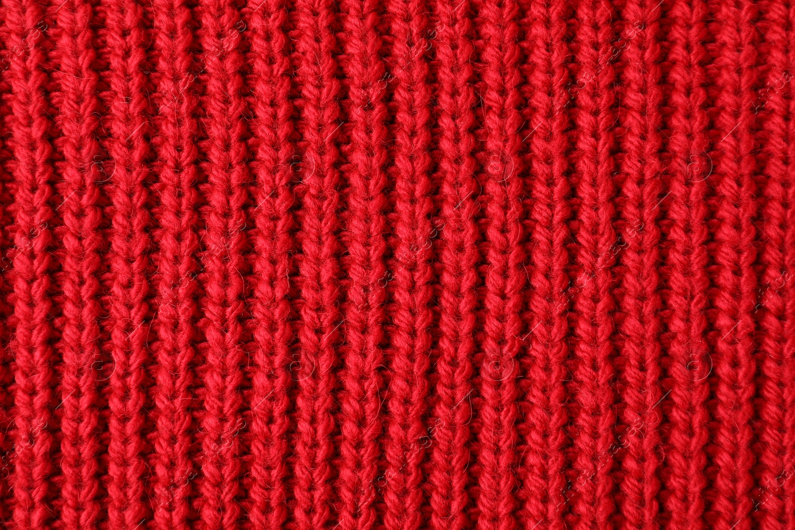 Photo of Texture of red knitted fabric as background, top view