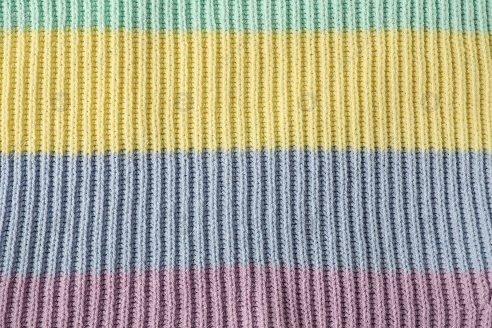 Photo of Texture of colorful knitted fabric as background, top view