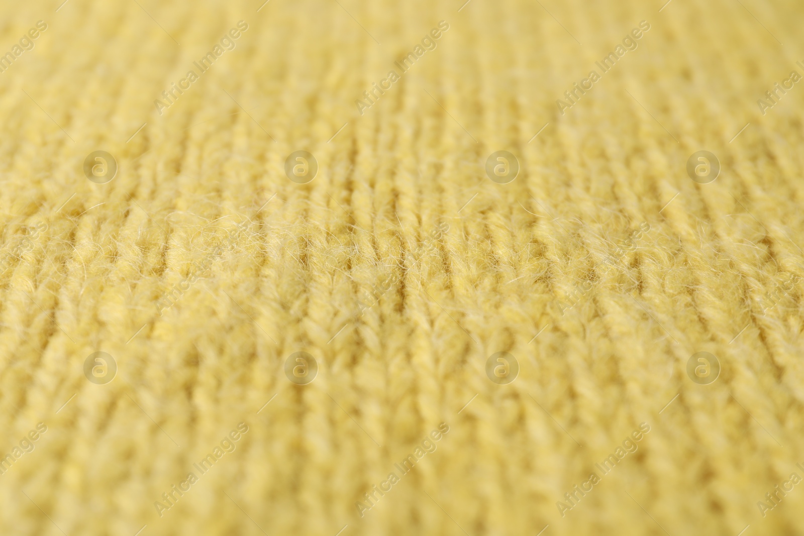 Photo of Texture of yellow knitted fabric as background, closeup