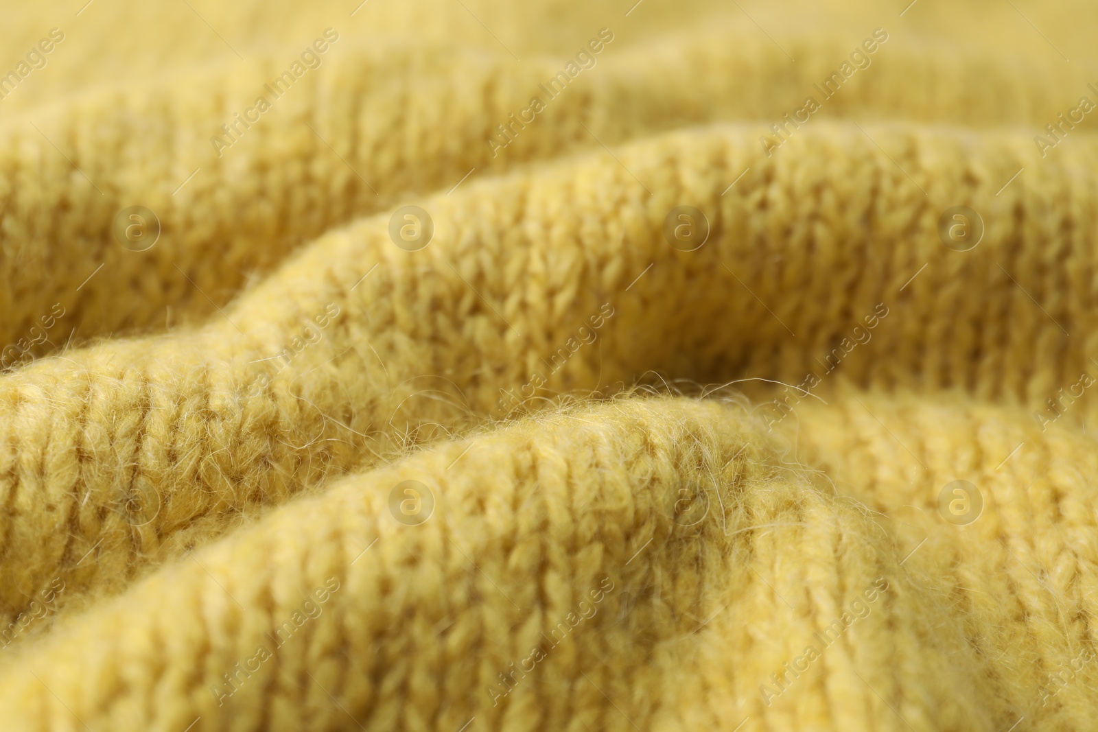 Photo of Texture of yellow knitted fabric as background, closeup