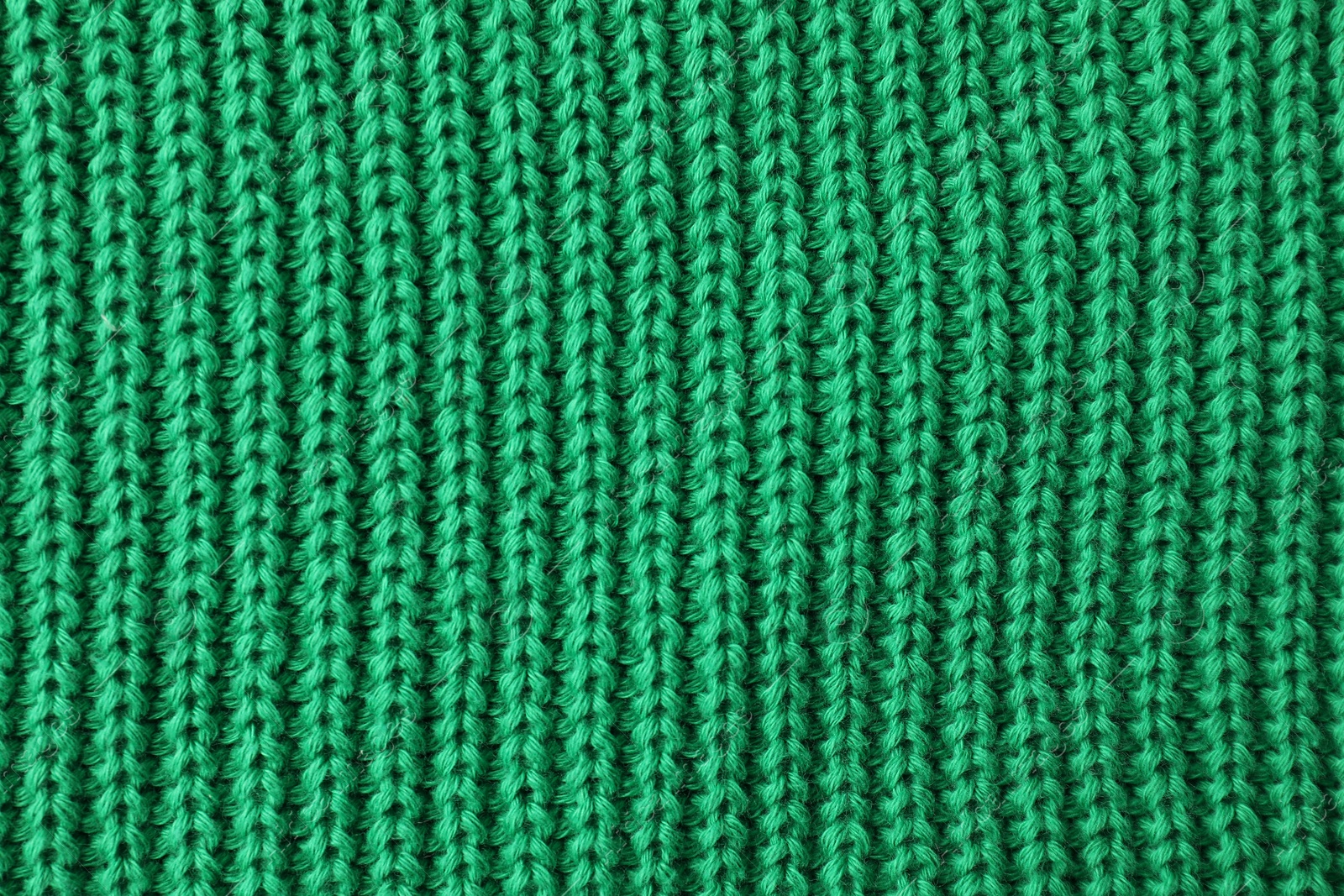 Photo of Texture of green knitted fabric as background, top view