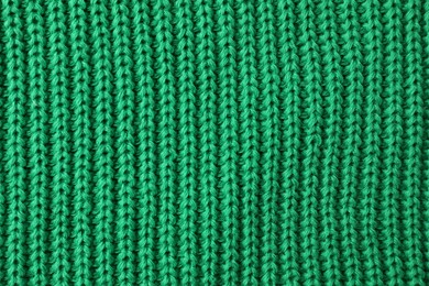 Texture of green knitted fabric as background, top view