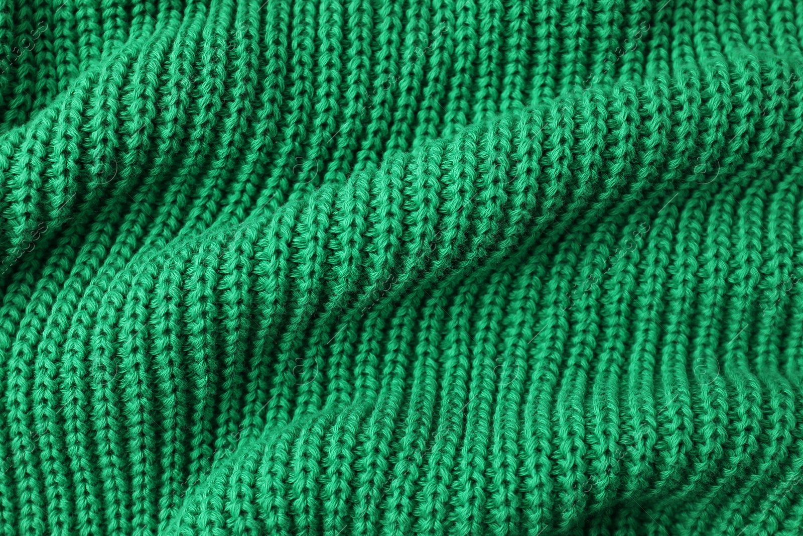 Photo of Texture of green knitted fabric as background, top view