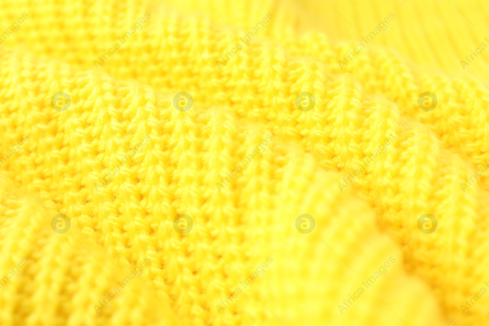 Photo of Texture of yellow knitted fabric as background, closeup