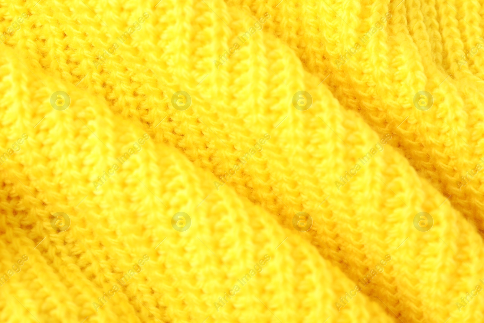 Photo of Texture of yellow knitted fabric as background, closeup