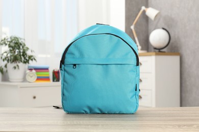 Photo of Light blue backpack on desk in room