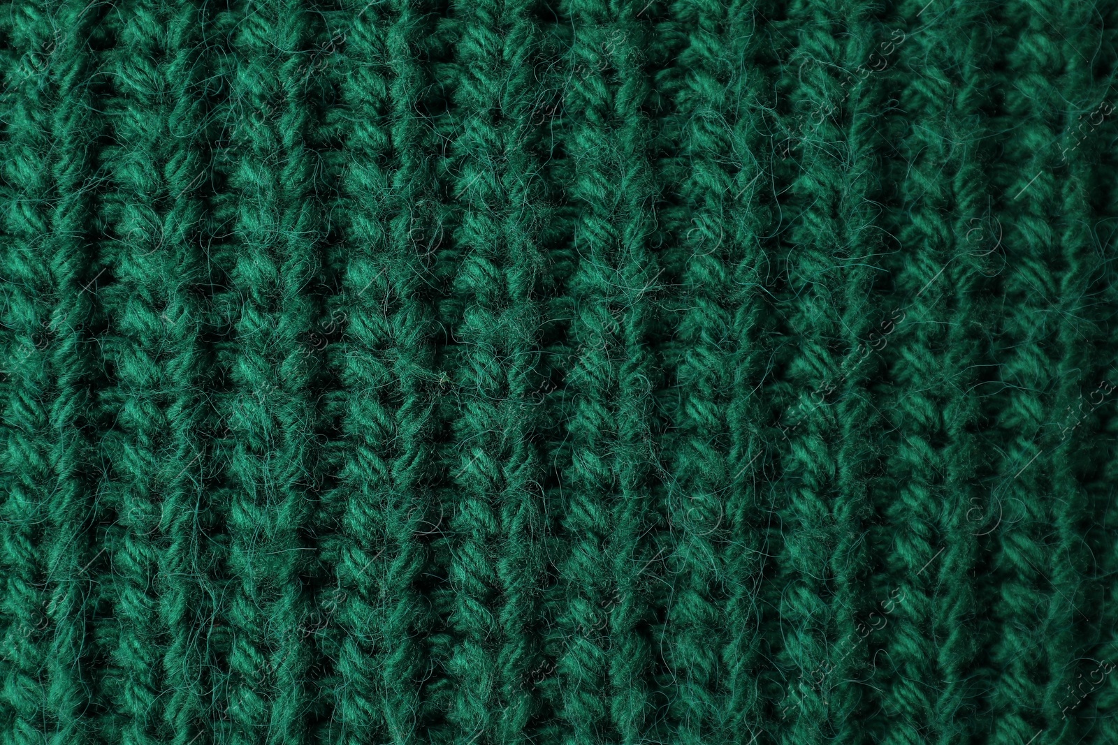 Photo of Texture of green knitted fabric as background, top view